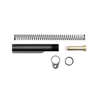 Top-down flat-lay product shot of a complete rifle buffer tube assembly kit including a black aluminum buffer tube, recoil spring, brass-toned buffer weight, end plate, and castle nut, isolated on a transparent background.
