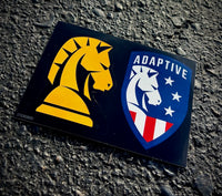 An Adaptive decal sticker sheet featuring a yellow knight emblem and a patriotic red, white, and blue shield logo on asphalt.