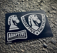 An Adaptive Tactical brand decal sticker sheet featuring knight logo graphics, resting on an asphalt surface.
